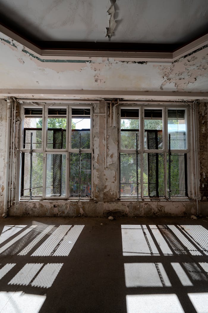 Sunlight filters through neglected windows in an abandoned building in Chemnitz, Germany.